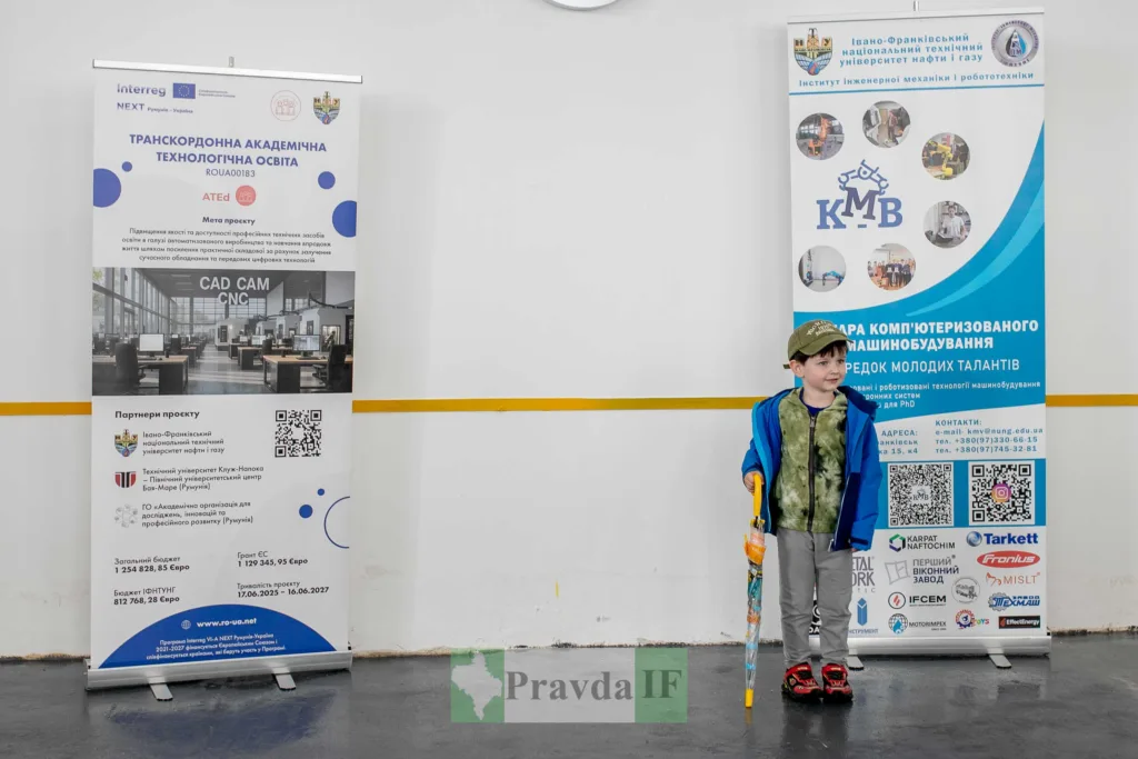 Хлопчик стоїть біля інформаційних банерів університету