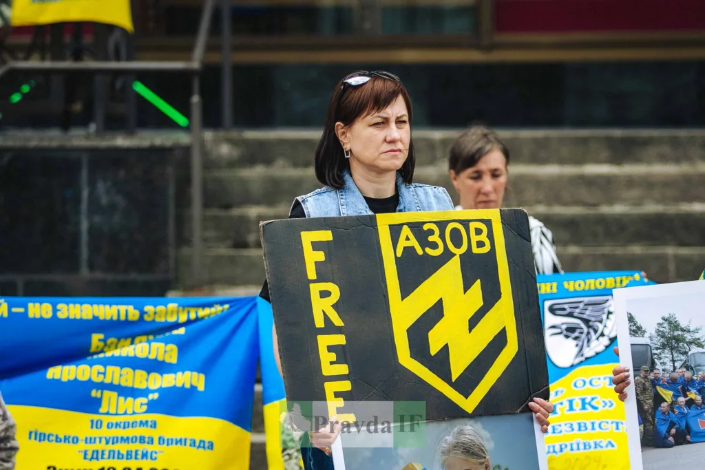 Жінка тримає плакат підтримки полку Азов