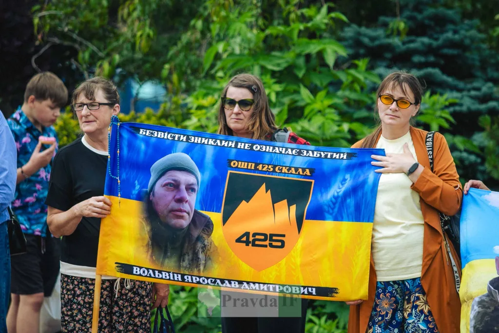 Жінки тримають банер із портретом зниклого військового