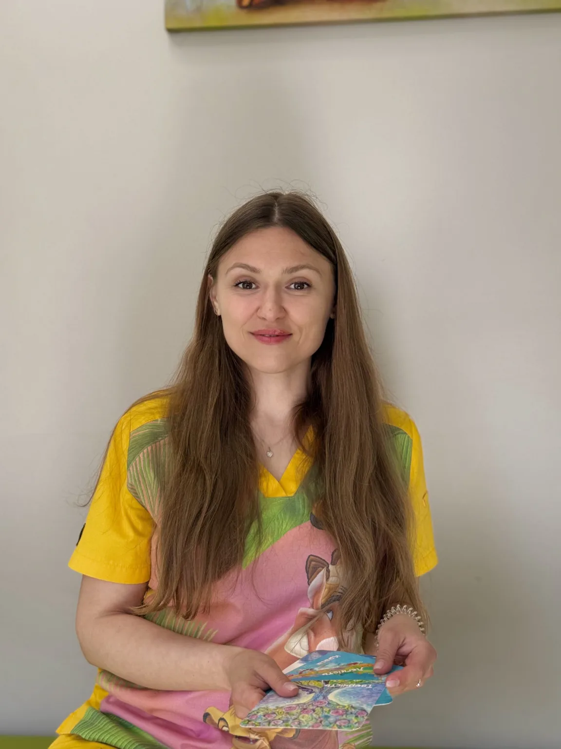 Жінка тримає кольорові листівки та усміхається