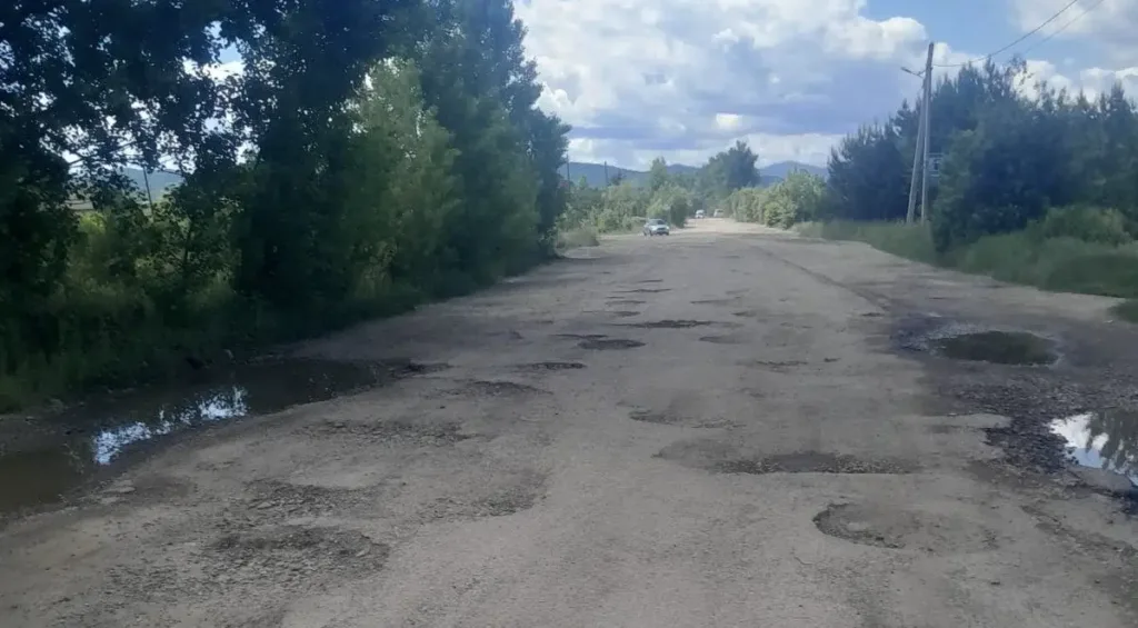 Пошкоджена дорога з ямами та калюжами