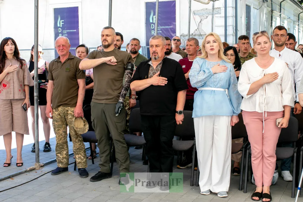 Люди стоять під час виконання гімну України