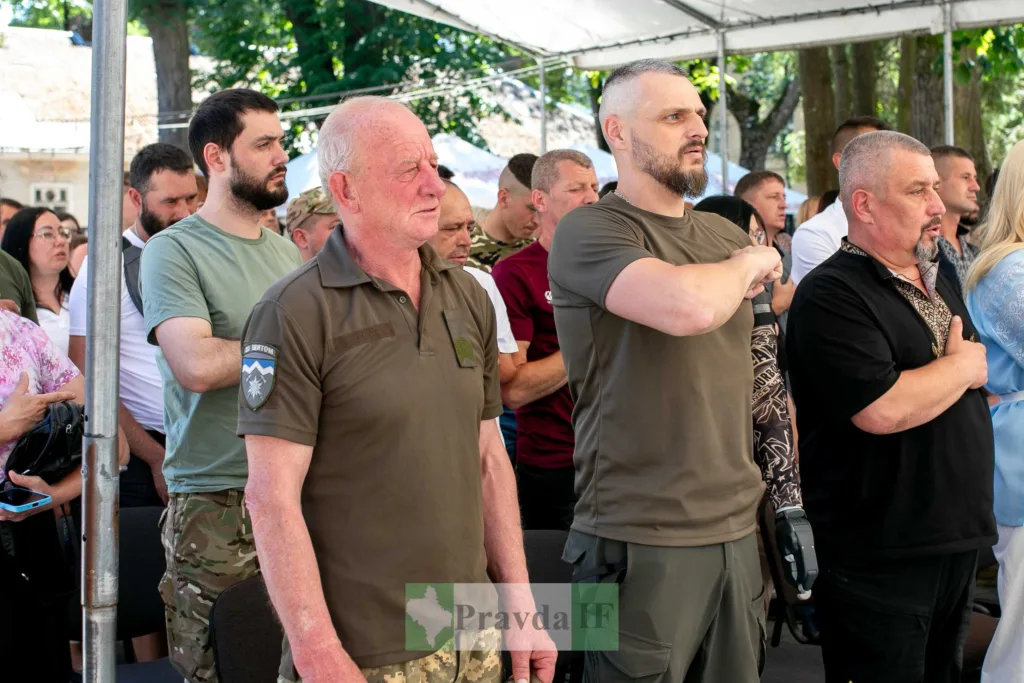 Люди стоять під час урочистої церемонії