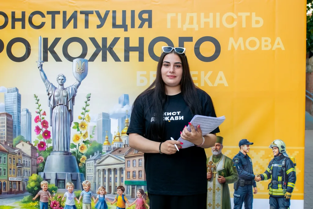 Жінка перед банером про Конституцію України
