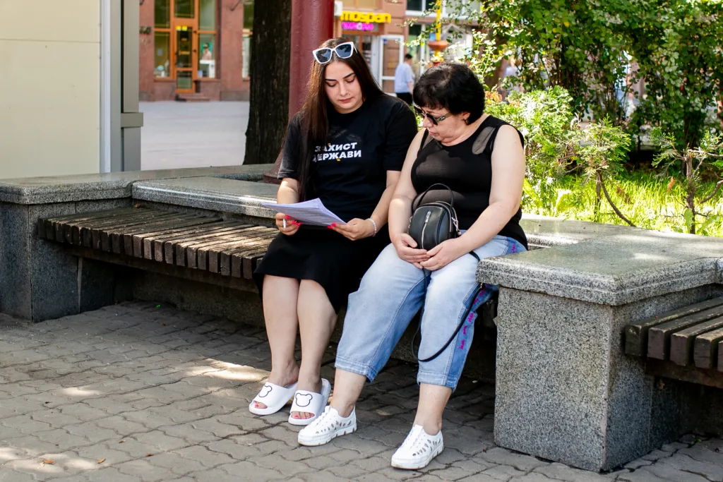 Дві жінки сидять на лаві в парку