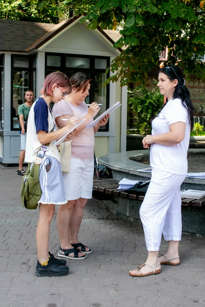 Люди заповнюють анкети на вулиці влітку