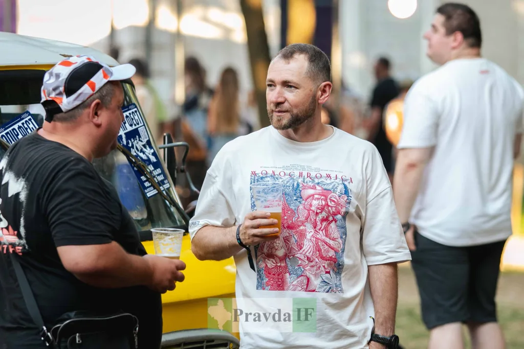 Двоє чоловіків розмовляють і п’ють напої на фестивалі