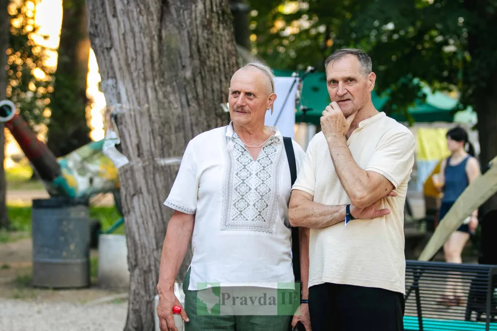 Двоє чоловіків розмовляють у парку влітку