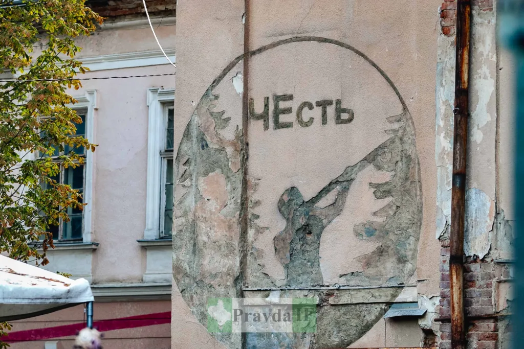 Старий радянський мурал із написом ЧЕСТЬ на стіні