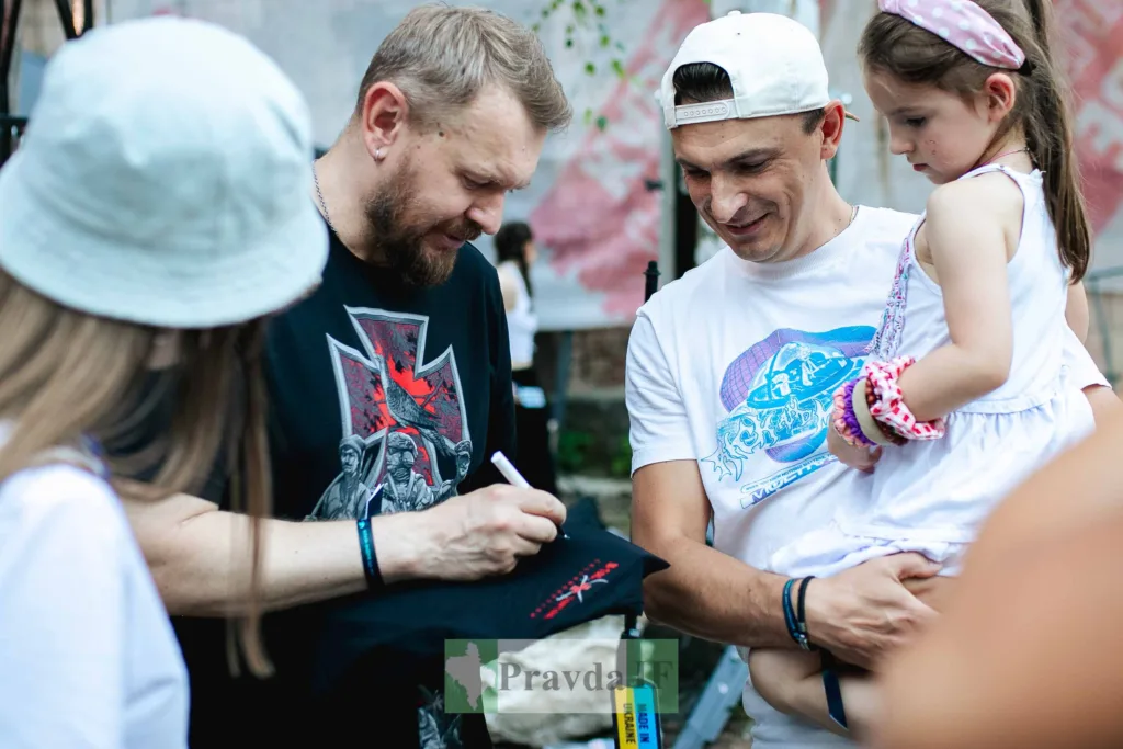 Чоловік підписує автограф на зустрічі з фанатами