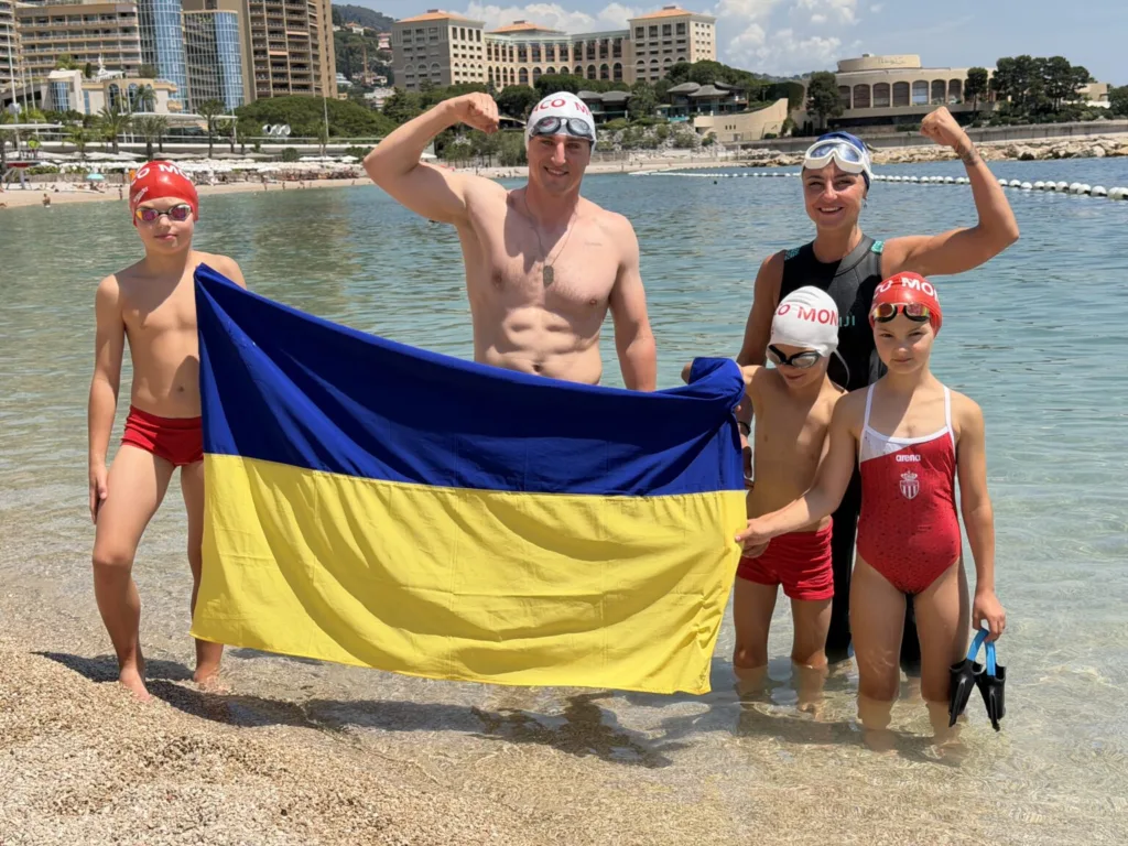 Плавці з українським прапором на морському узбережжі