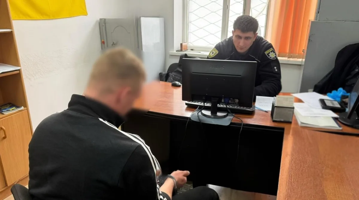 Поліцейський допитує затриманого у відділку поліції