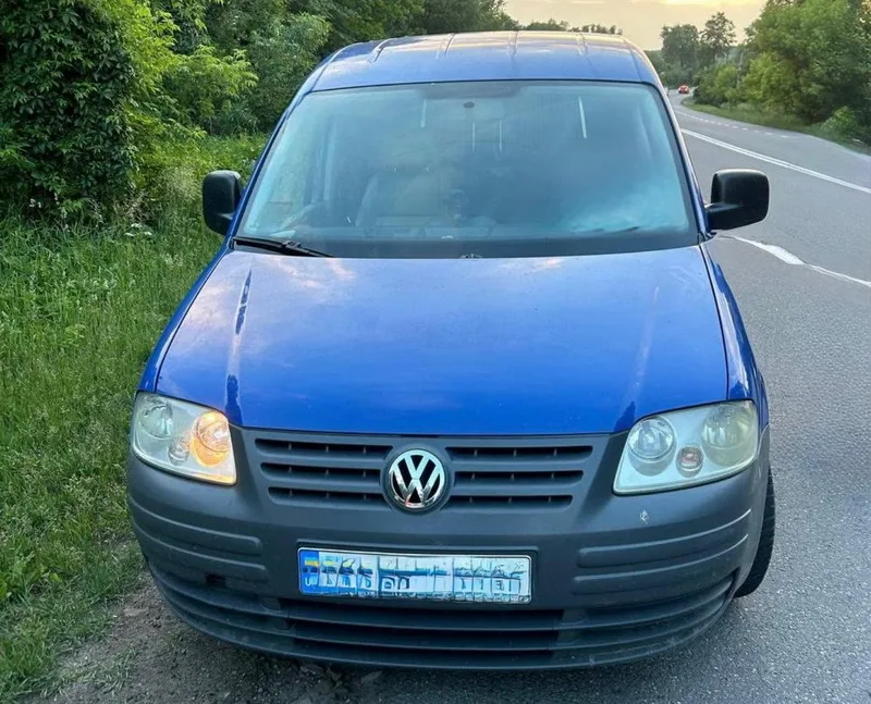 Синій фургон Volkswagen стоїть біля дороги