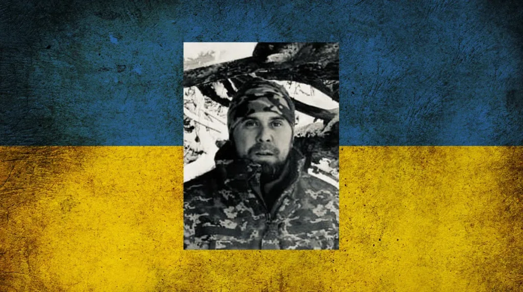 Військовий у камуфляжі на тлі прапора України