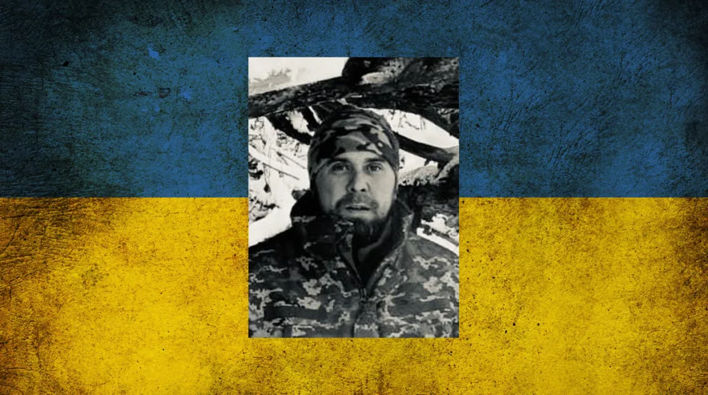 Військовий у камуфляжі на тлі прапора України