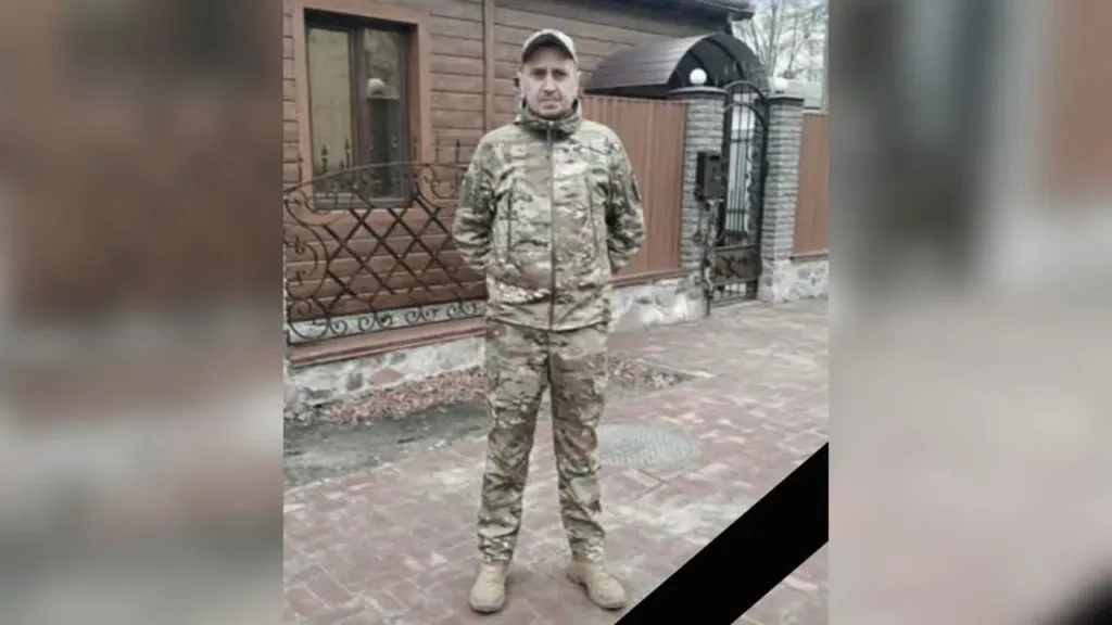 Військовий у камуфляжі стоїть перед будинком