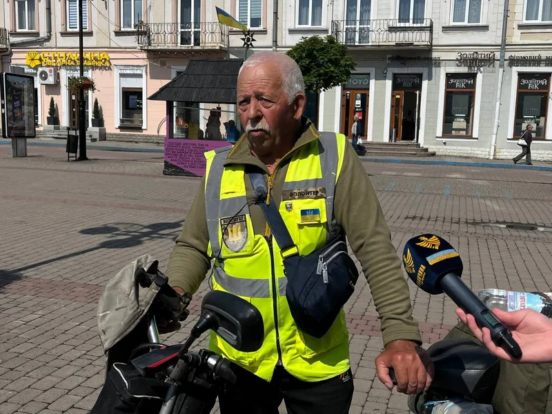 Волонтер у жовтому жилеті дає інтерв'ю на вулиці