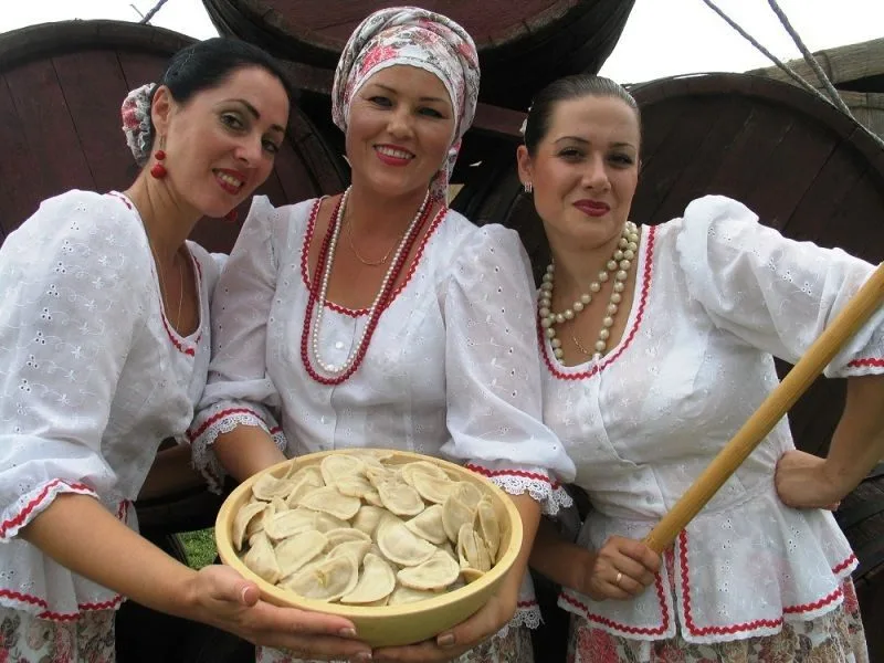 Жінки у вишиванках тримають миску вареників