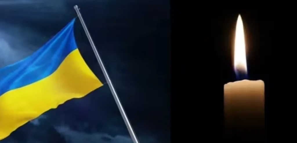 Прапор України та запалена свічка пам’яті