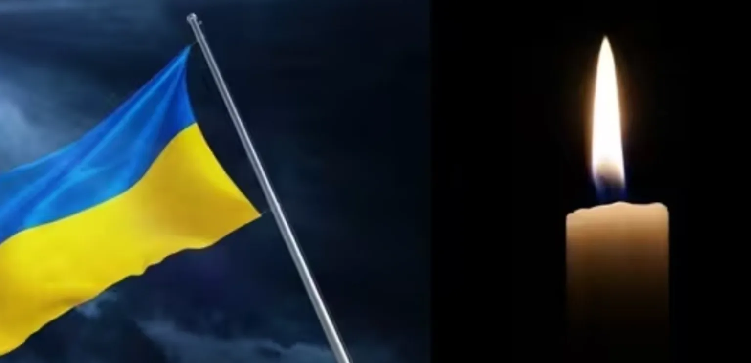 Прапор України та запалена свічка пам’яті