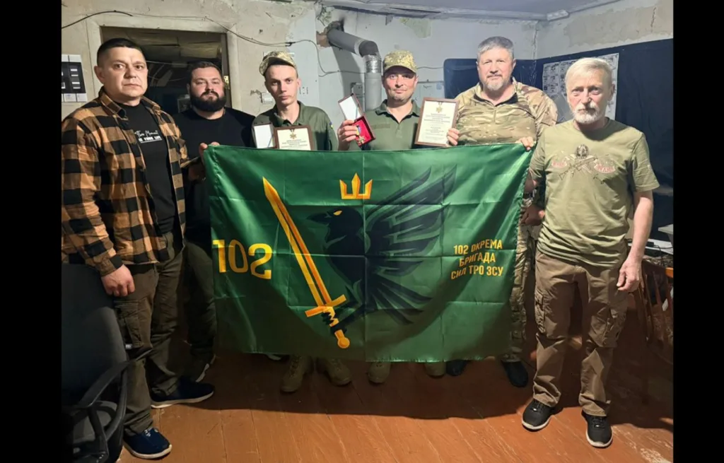 Військові тримають прапор 102 окремої бригади ТрО