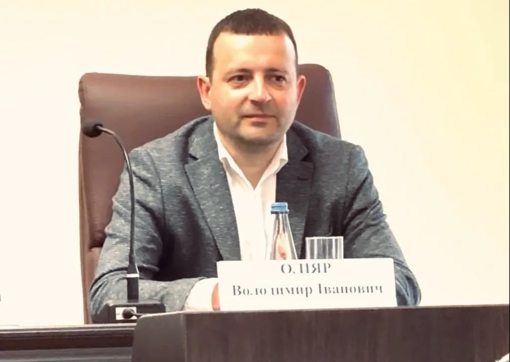 Чоловік сидить за столом на конференції