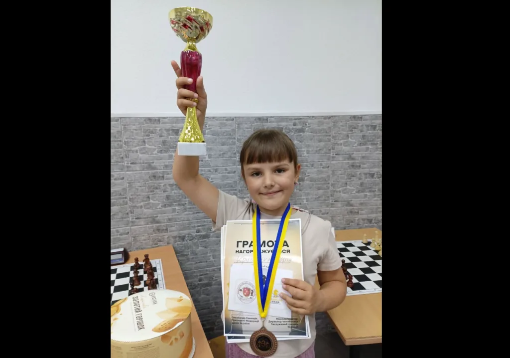 Дівчинка з кубком і медаллю на шаховому турнірі
