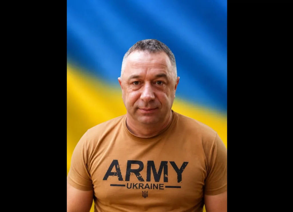 Чоловік у футболці Army Ukraine перед прапором України