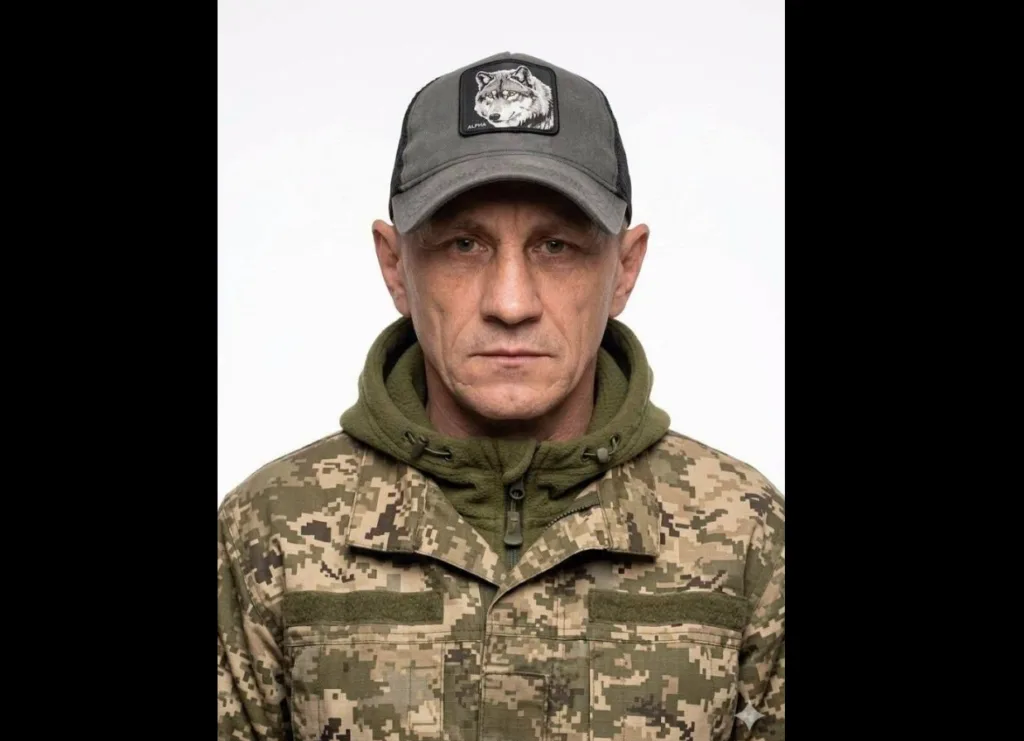 Військовий у камуфляжі та кепці з вовком