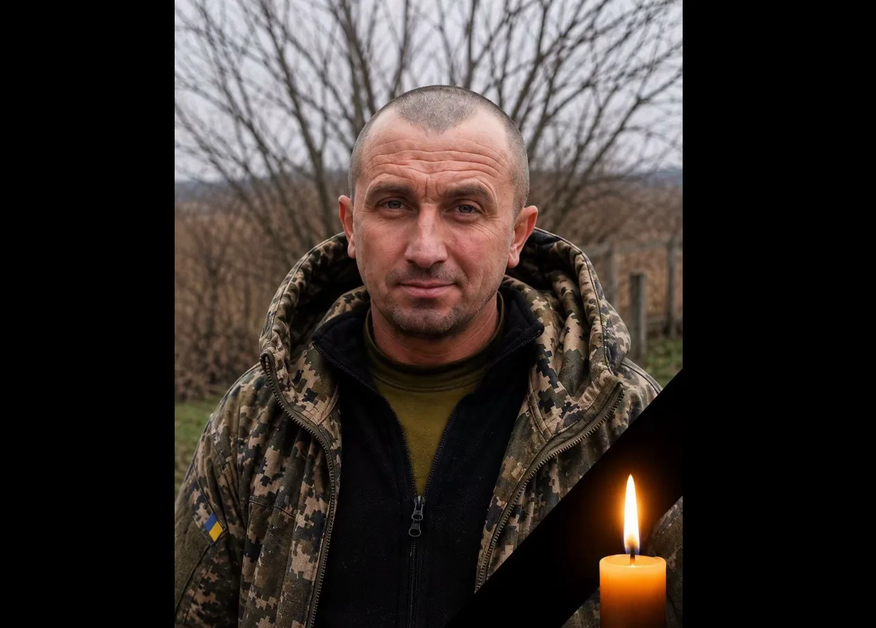 Український військовий у камуфляжі з палаючою свічкою