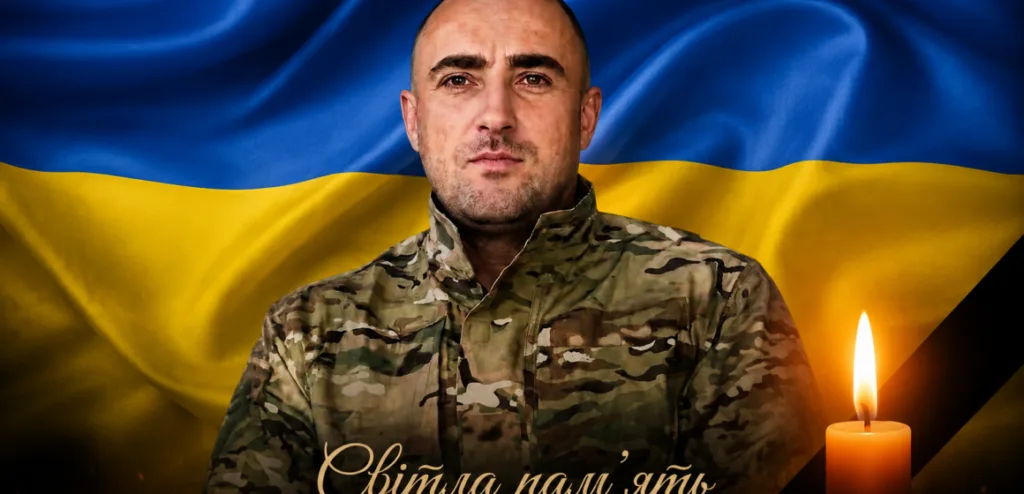 Український військовий перед прапором України з свічкою