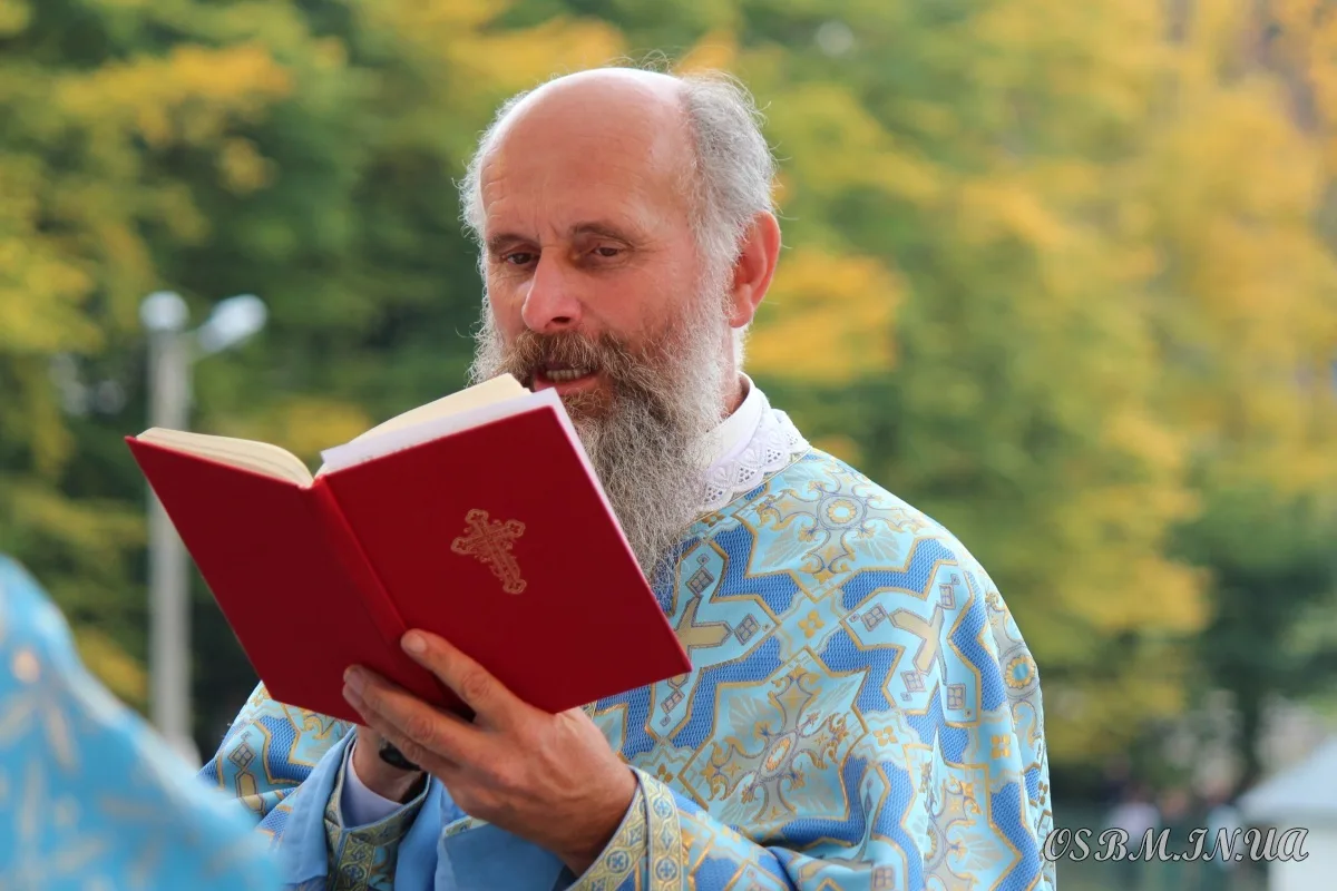 Священник читає молитву з червоної книги