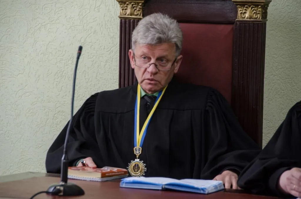 Суддя в мантії сидить за столом у залі суду