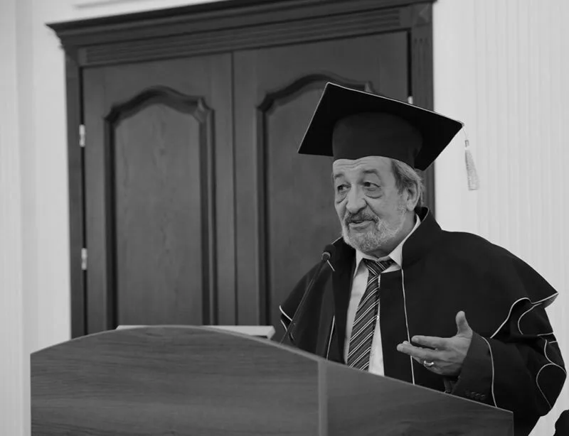 Професор у академічному одязі виступає на церемонії