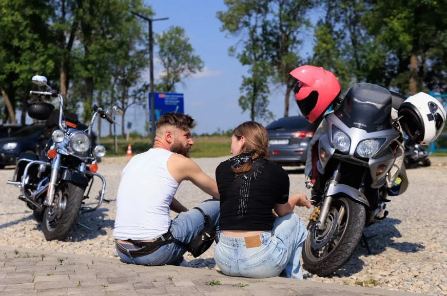 Пара відпочиває біля мотоциклів на парковці