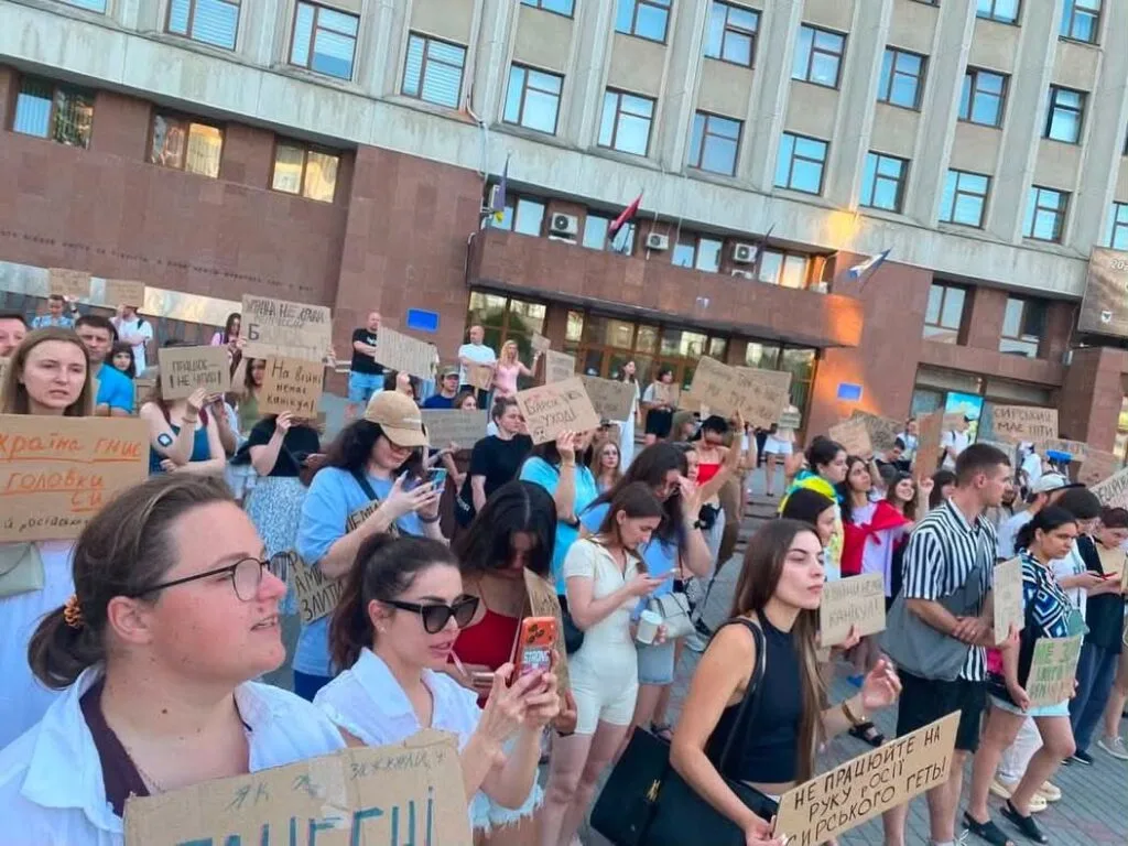 Мітинг людей із плакатами біля будівлі