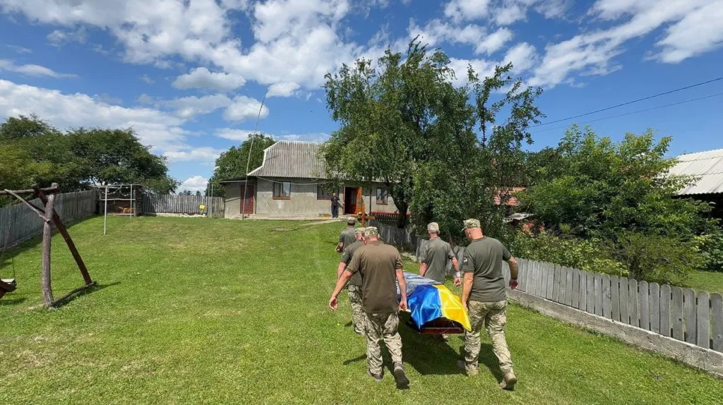 Військові несуть труну з українським прапором