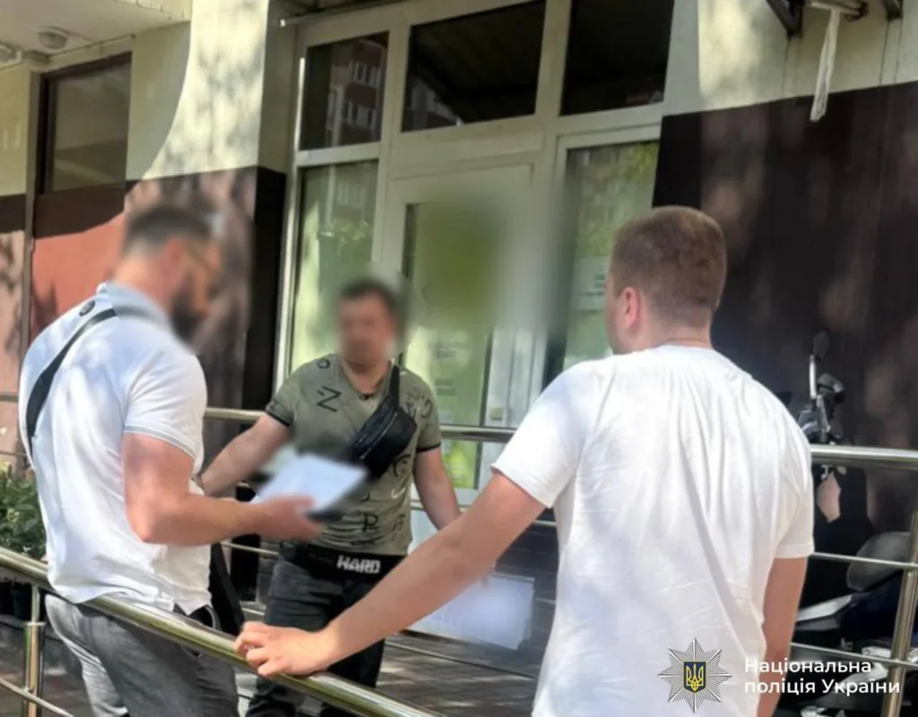 Поліція спілкується з чоловіком біля будівлі