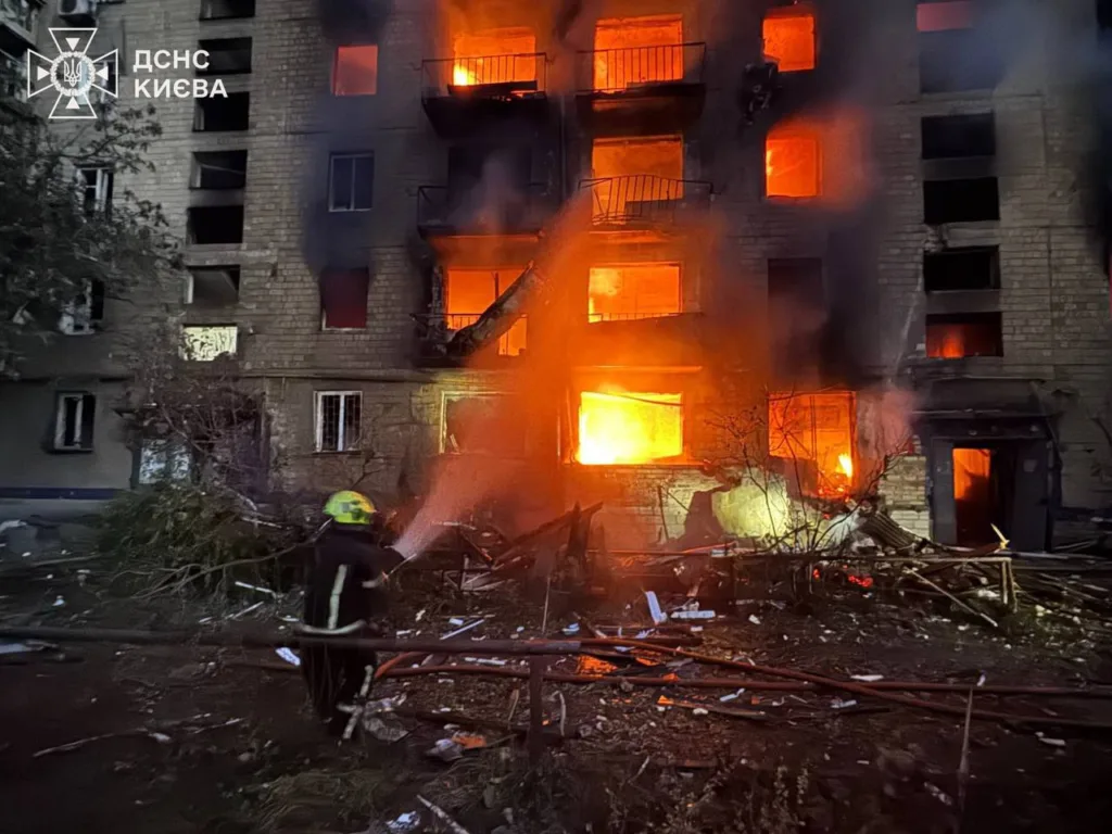 Пожежник гасить вогонь у будинку в Києві