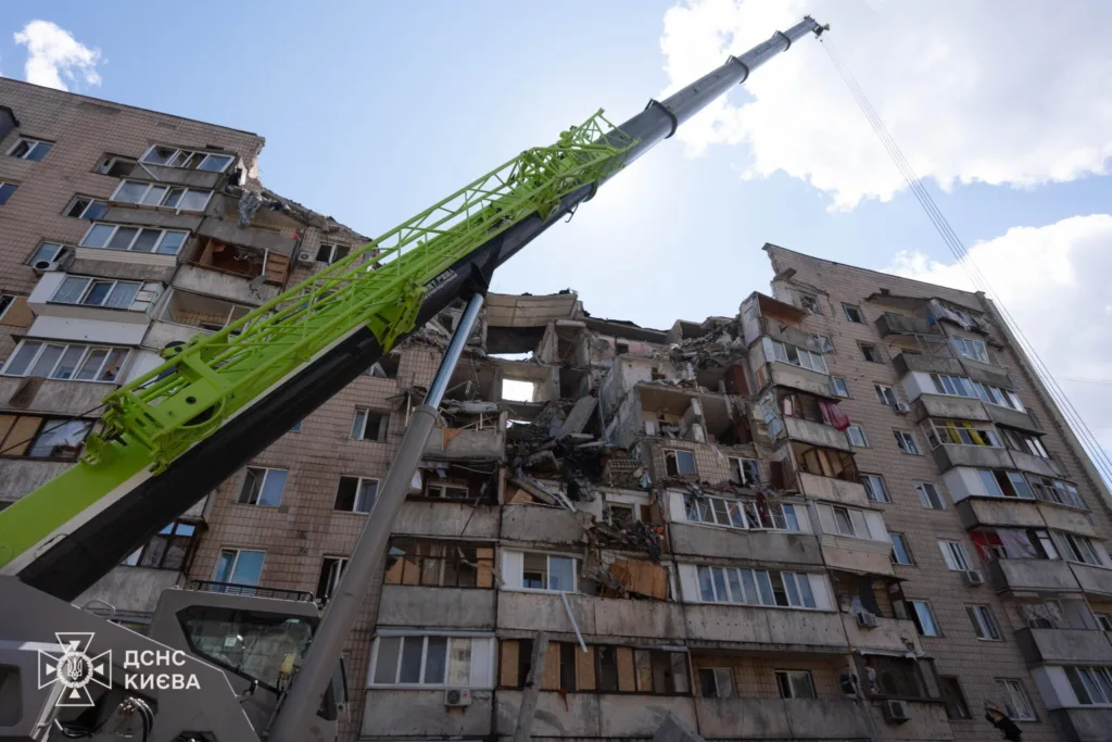 Пошкоджений будинок і рятувальний кран у Києві