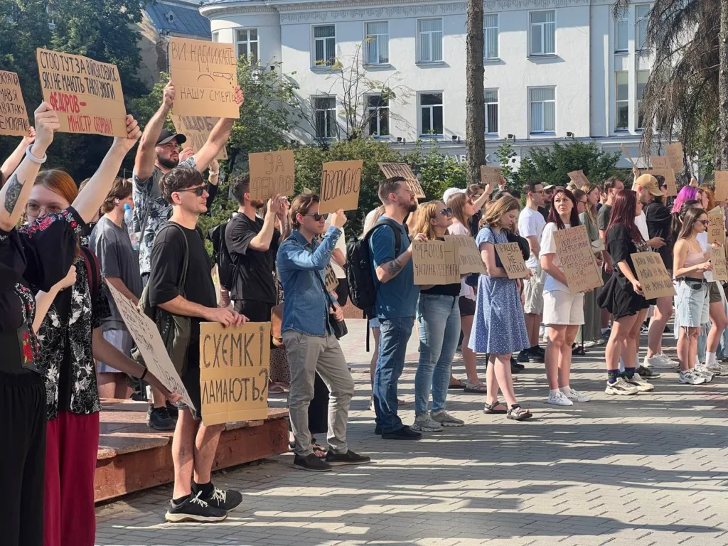Люди тримають плакати на мирному протесті у місті