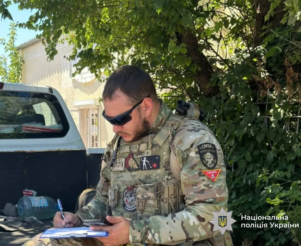 Сапер поліції України заповнює документи на вулиці