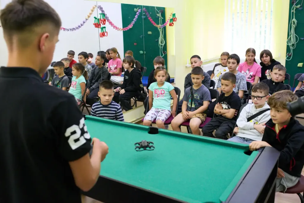 Діти спостерігають за демонстрацією дрона в класі