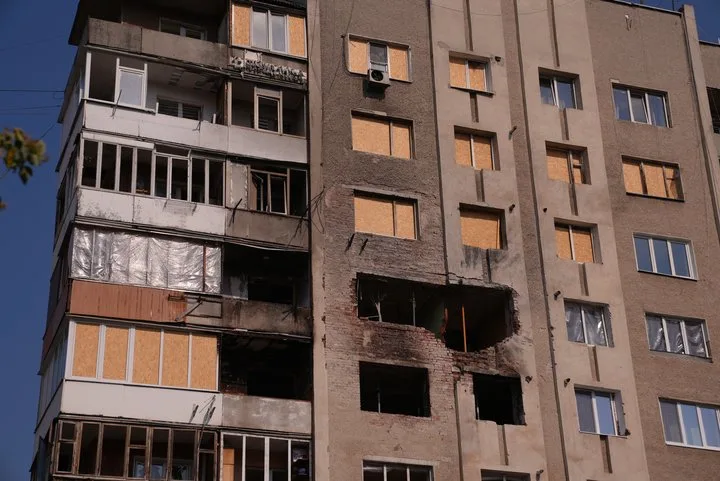Пошкоджений житловий будинок із забитими вікнами