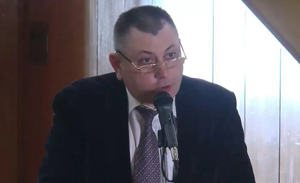 Чоловік у костюмі говорить у мікрофон
