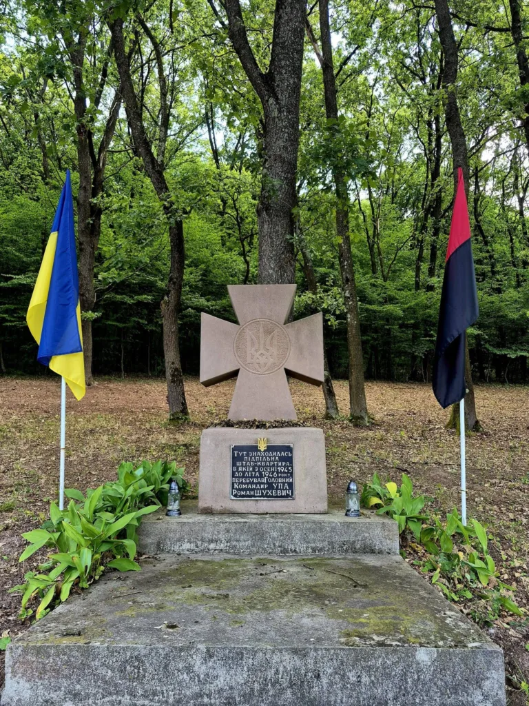 Пам’ятник УПА з прапорами у лісі