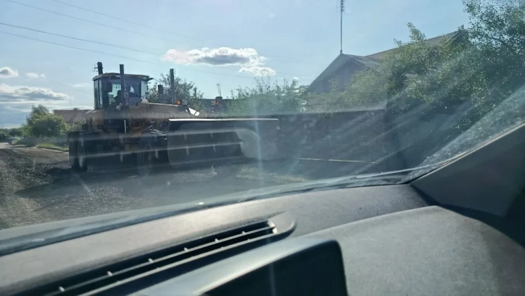 Бульдозер ремонтує сільську дорогу під сонцем
