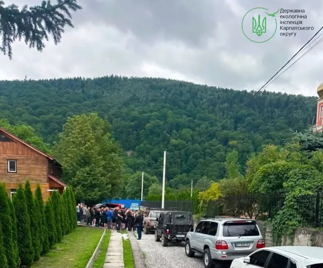 Люди та автомобілі біля гір у Карпатах