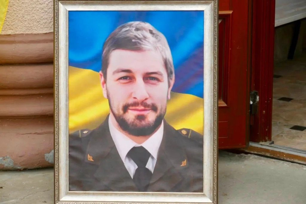Портрет військового перед прапором України