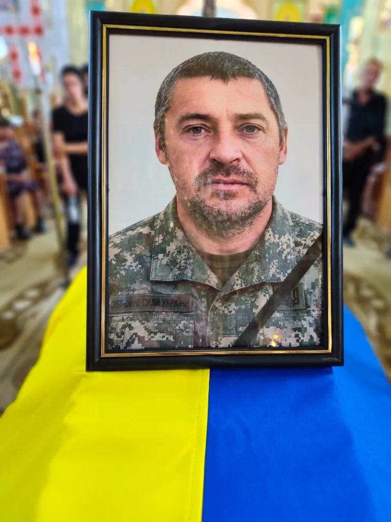 Портрет військового на труні з прапором України